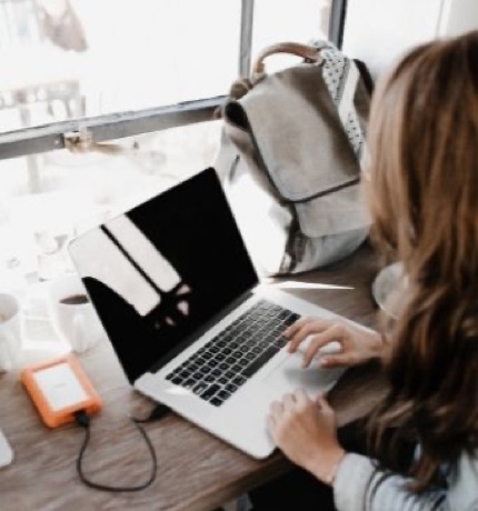 Person working on a laptop in a quiet space, benefiting from effective acoustic insulation for improved focus and productivity.